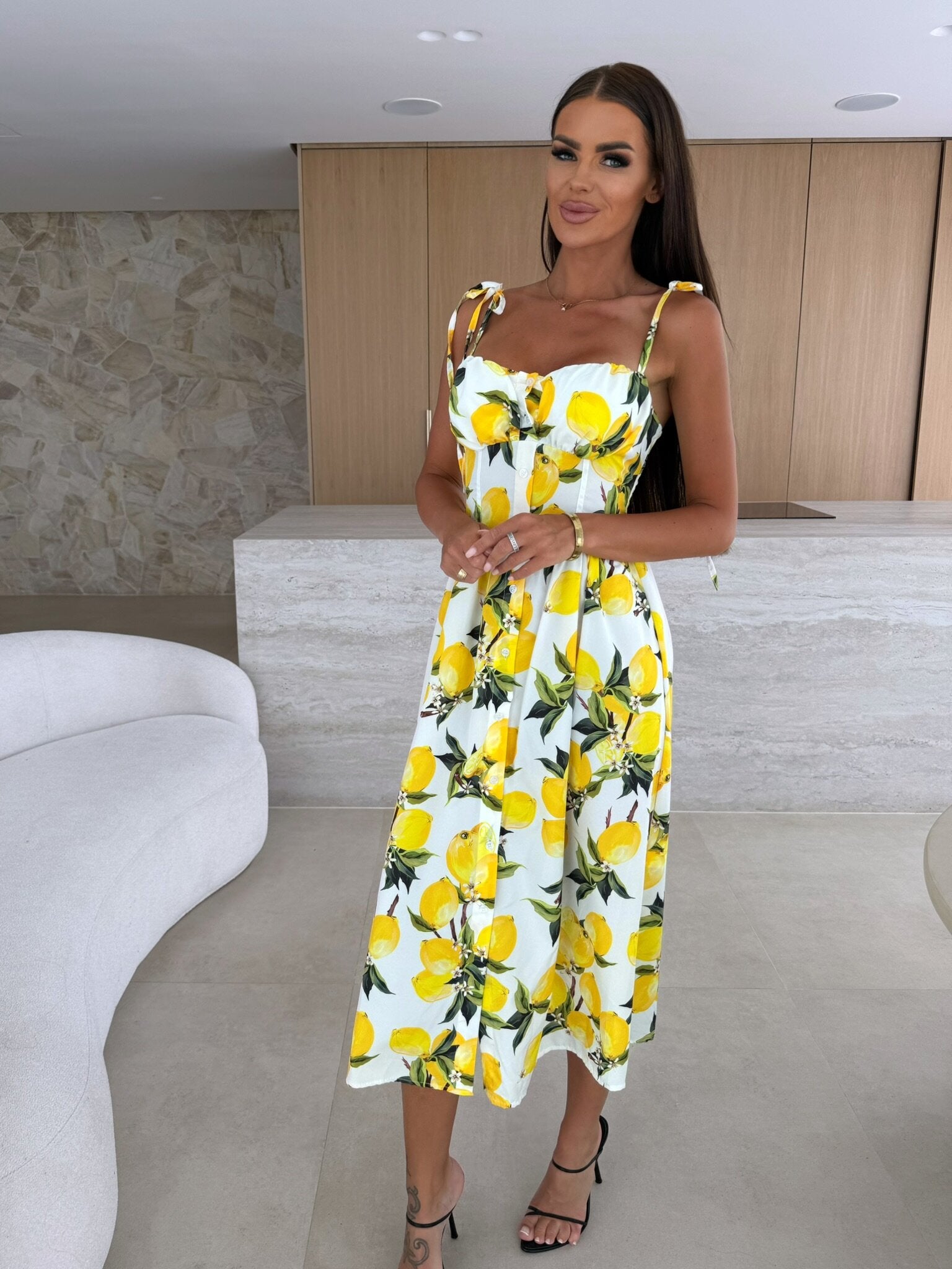 Woman wearing a yellow floral dress in an indoor setting