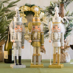 Three decorative nutcrackers on a table with Christmas decorations in the background