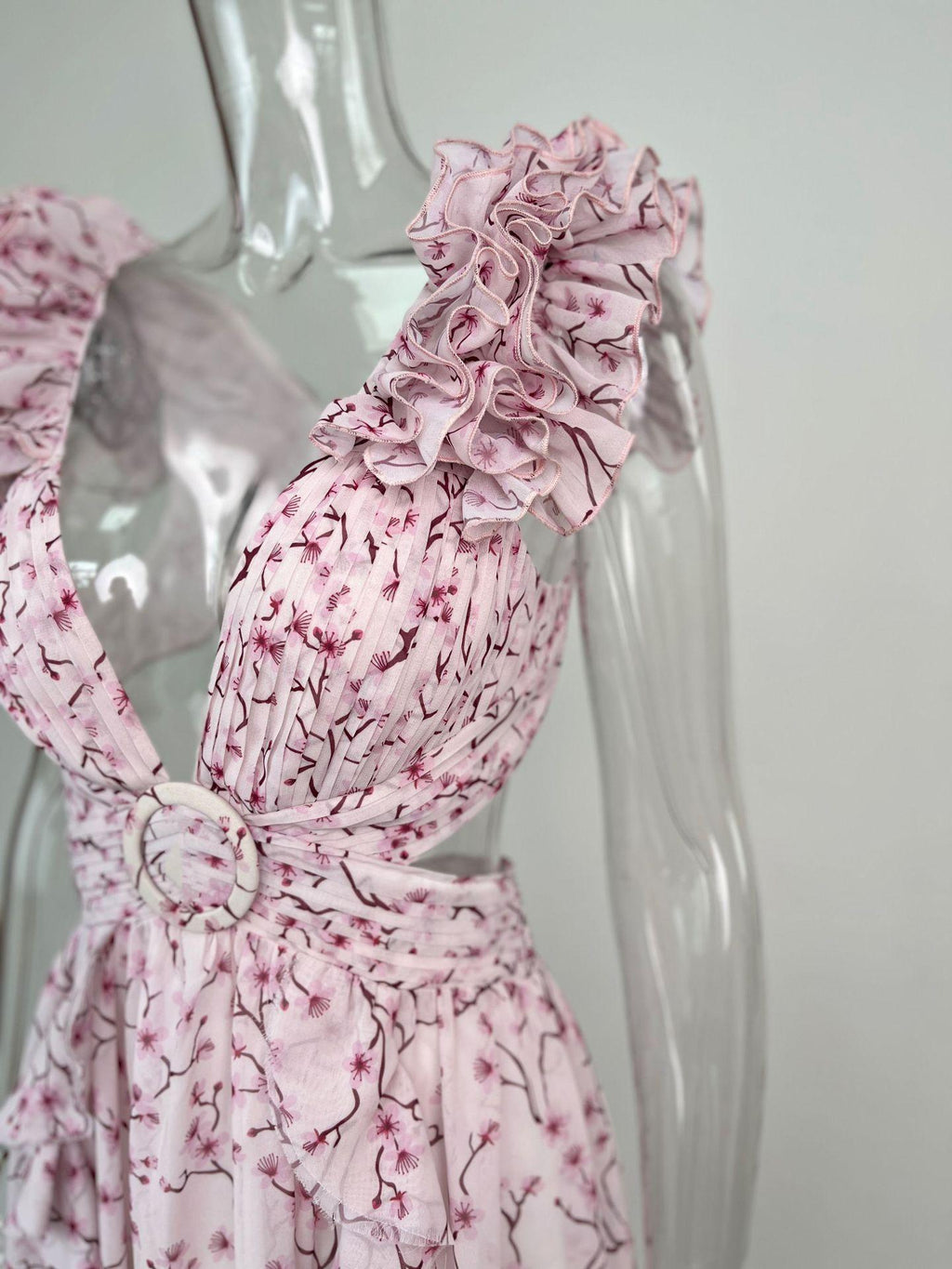 Pink floral dress on a mannequin against a plain background