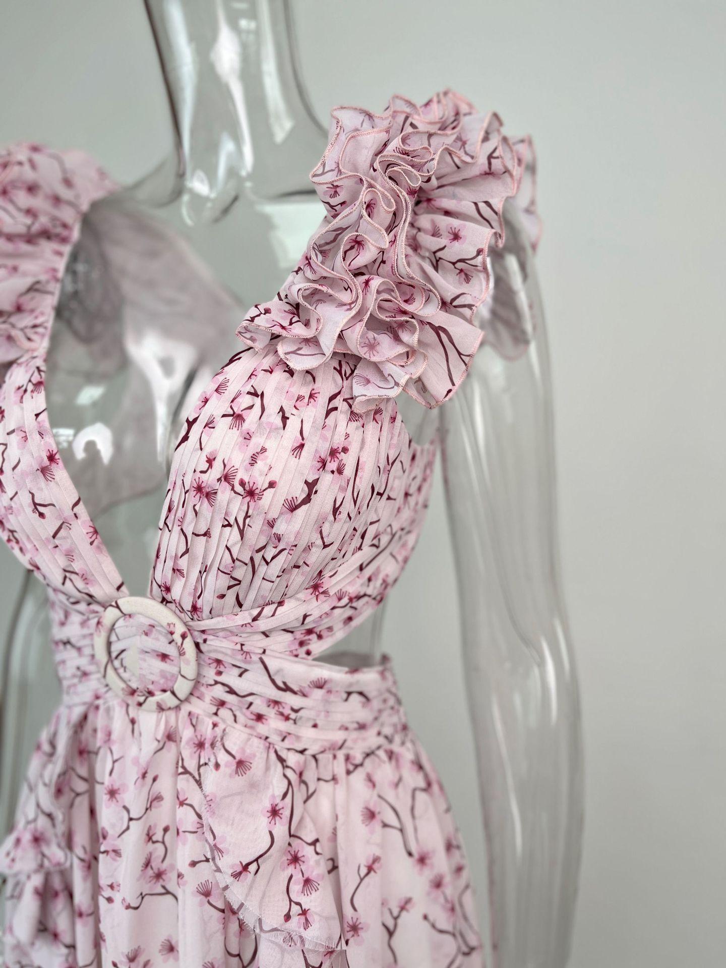 Pink floral dress on a mannequin against a plain background