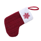 Red knitted Christmas stocking with a white cuff and red snowflake design on a white background