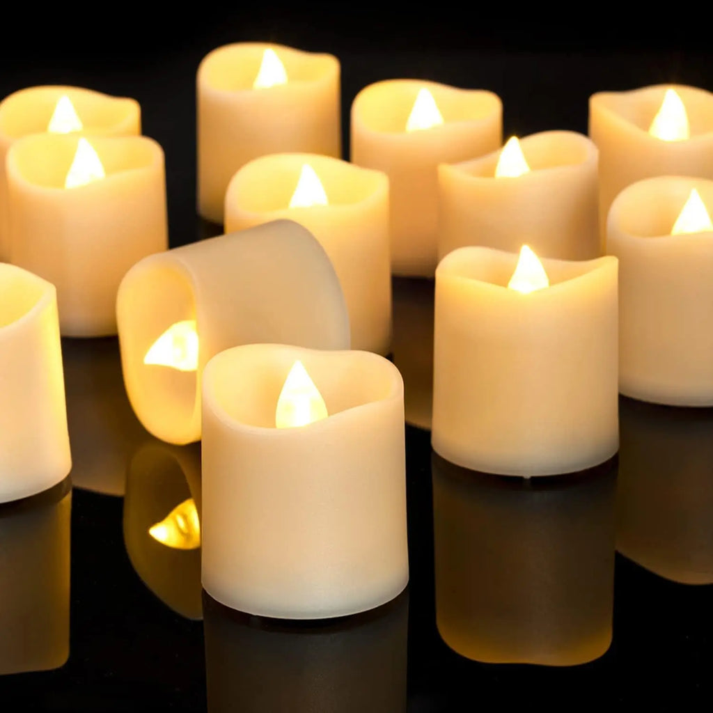 Multiple lit candles on a reflective surface with a dark background