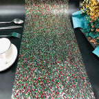 Colorful beaded table runner on a black table with cutlery and a cup.