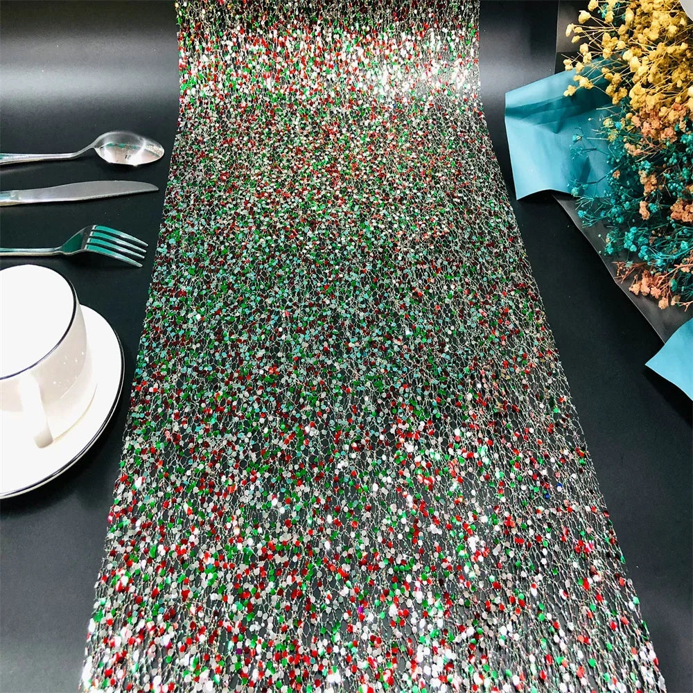 Colorful beaded table runner on a black table with cutlery and a cup.