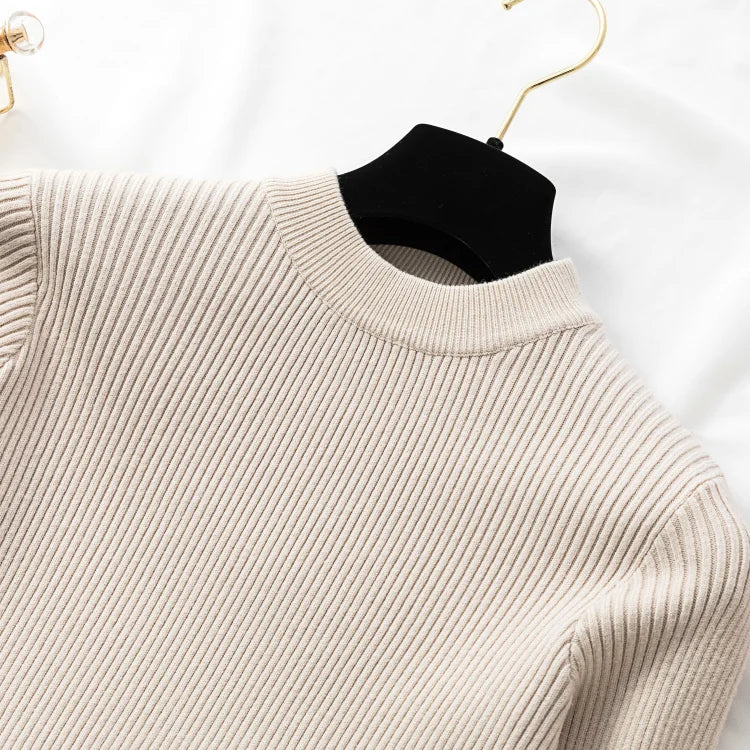 Beige ribbed sweater on a hanger against a white background