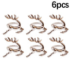 Set of six rose gold deer antler-shaped rings on a white background