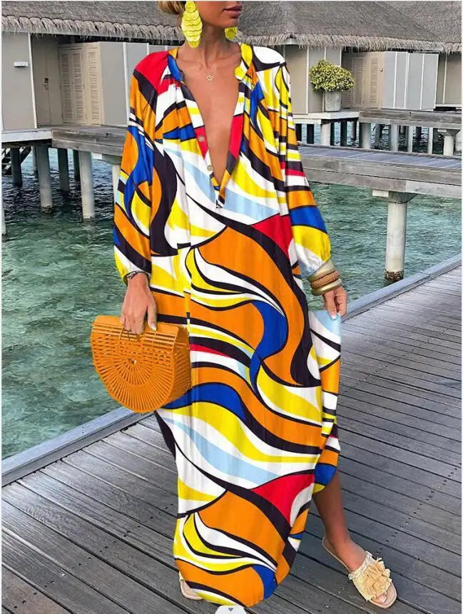 Woman wearing a colorful patterned dress on a wooden deck by water.