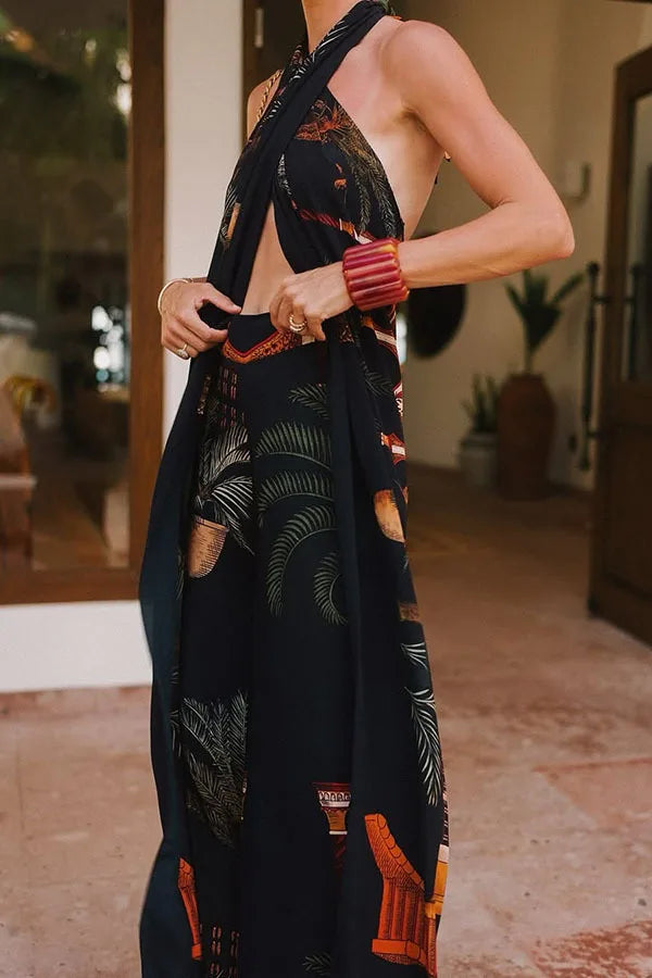 Person wearing a black dress with red and green patterns in an indoor setting.
