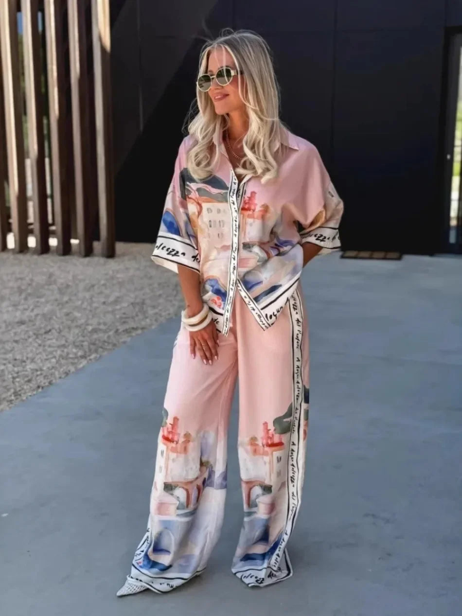 Woman wearing a stylish pink outfit with floral patterns outdoors.
