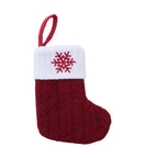 Red knitted Christmas stocking with a white cuff featuring a red snowflake design on a white background.