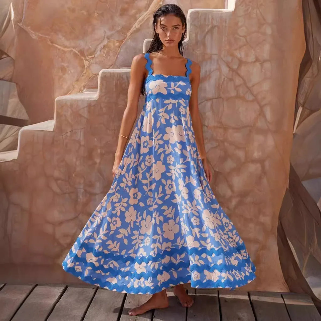 Woman wearing a blue floral dress standing on a wooden platform with a stone wall background