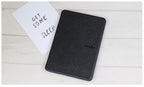 Black Kindle cover on a light wooden surface with a white card reading 'Get some sleep'.