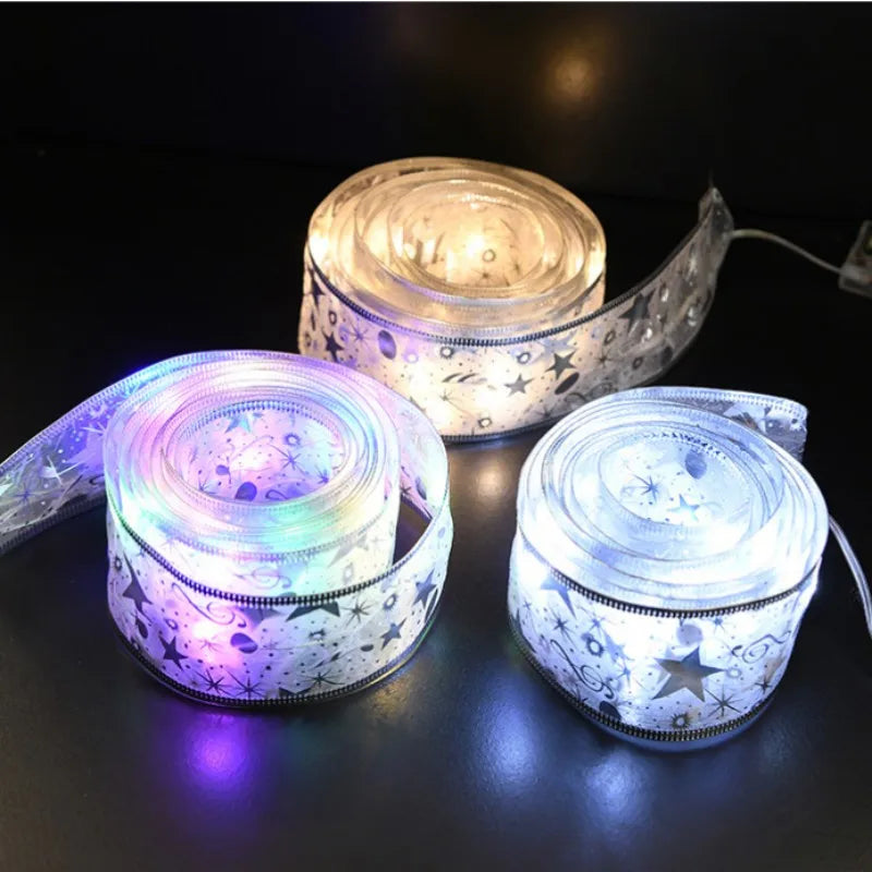 Three rolls of LED strip lights glowing in different colors on a dark surface.