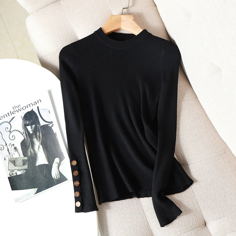 Black sweater with button details on a beige surface