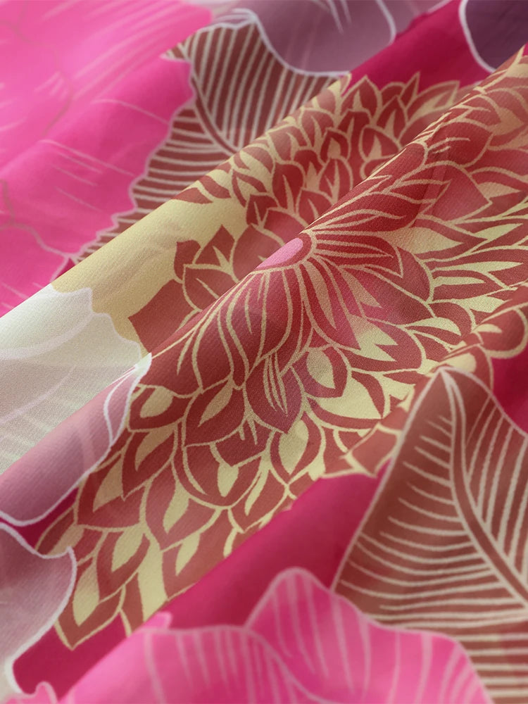 Close-up of a fabric with a red and yellow floral pattern on a pink background