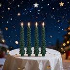 Five green tree-shaped candles on a table with a starry night background