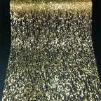 Close-up of a gold and black sequin fabric with a dark background
