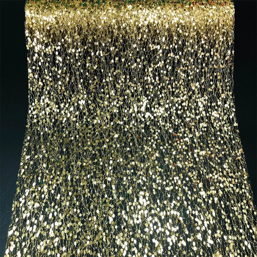 Close-up of a gold and black sequin fabric with a dark background