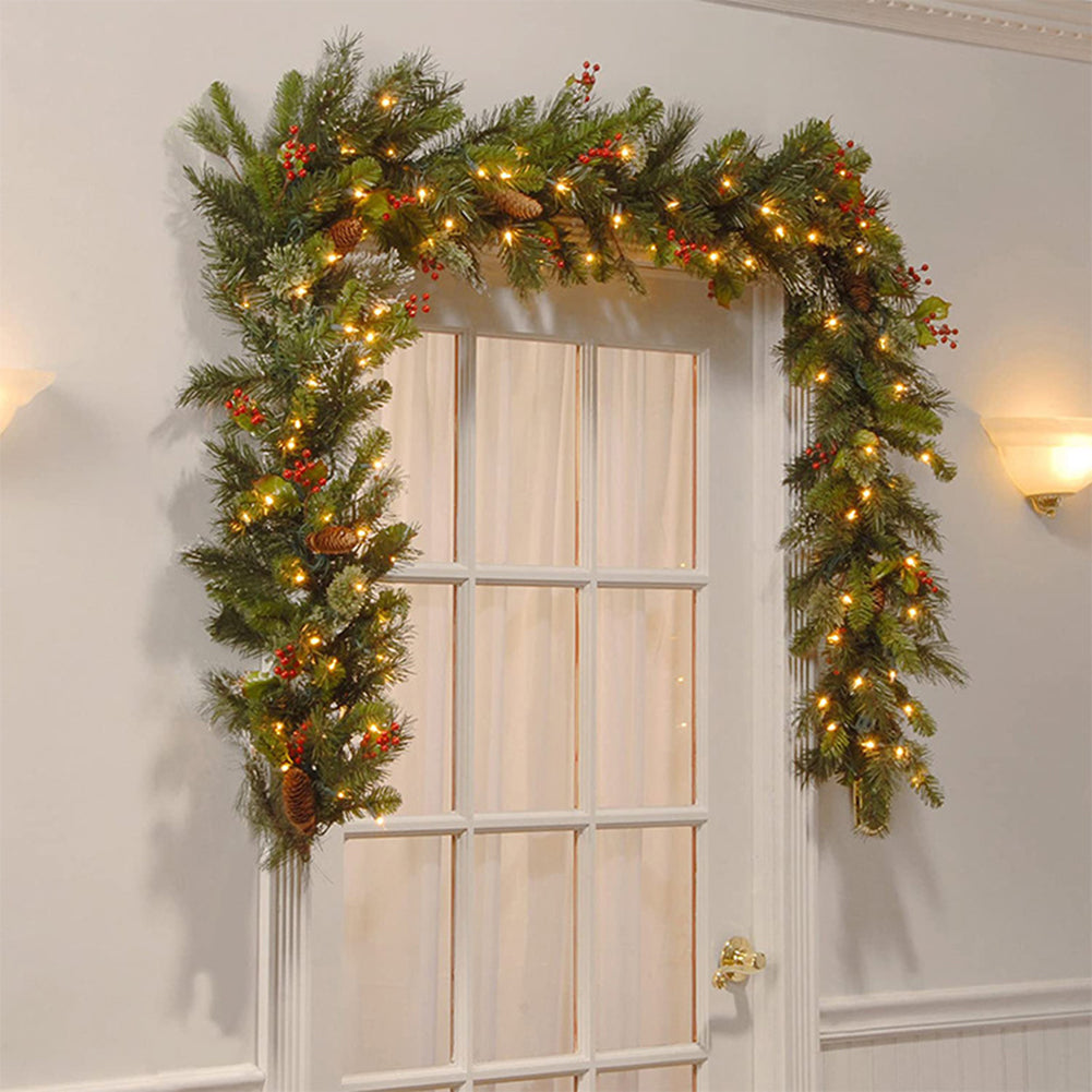Decorative Christmas garland with lights and ornaments hanging above a door.