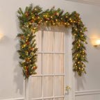 Decorative Christmas garland with lights and ornaments hanging above a door.