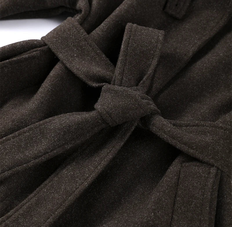 Close-up of a brown coat with a tie waist on a white background