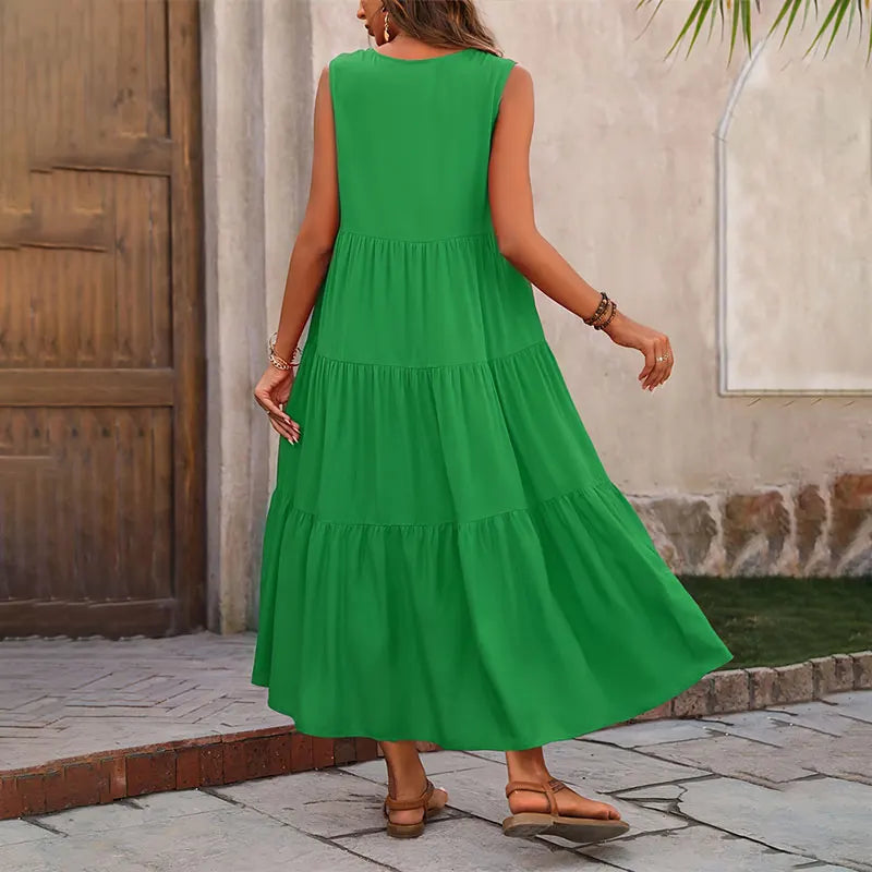 Woman wearing a green dress standing outdoors near a wooden door.