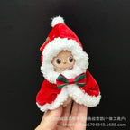 Small plush toy dressed in a Santa Claus outfit held against a black background