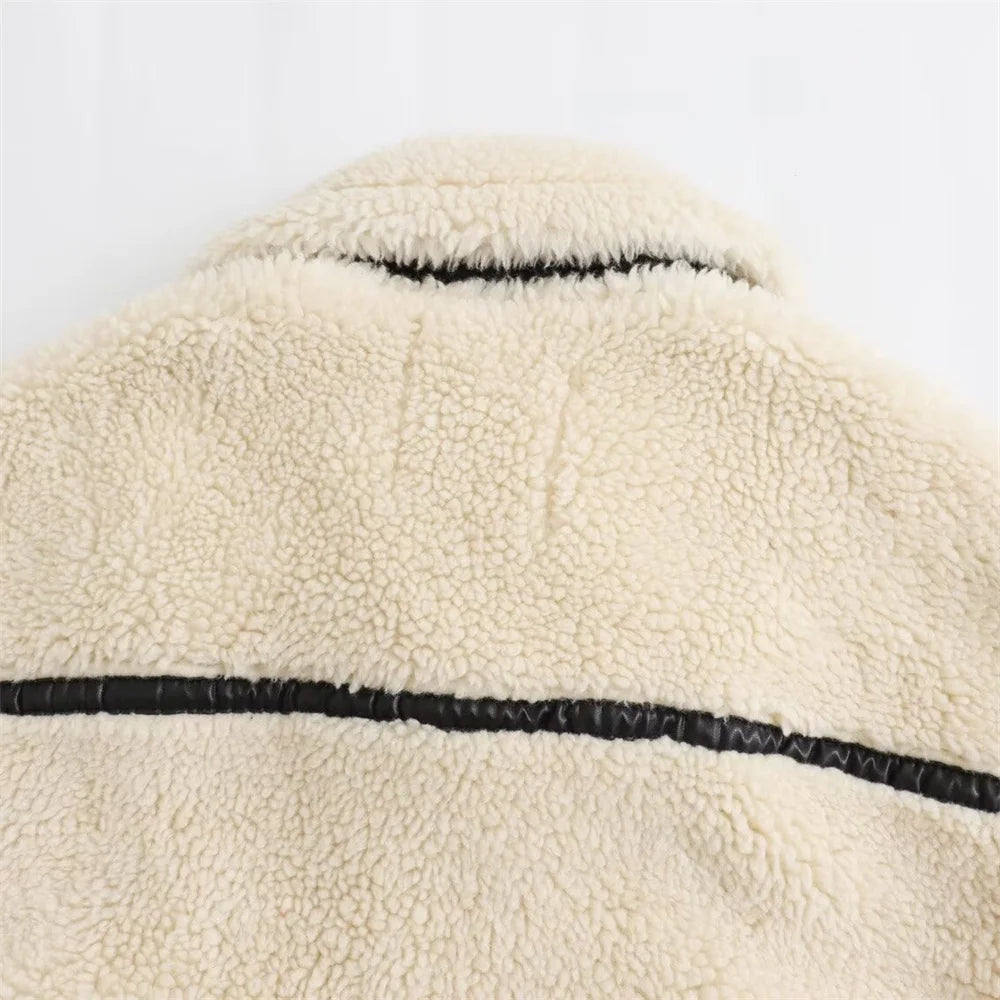 Close-up of a beige fleece jacket with black stitching on a white background