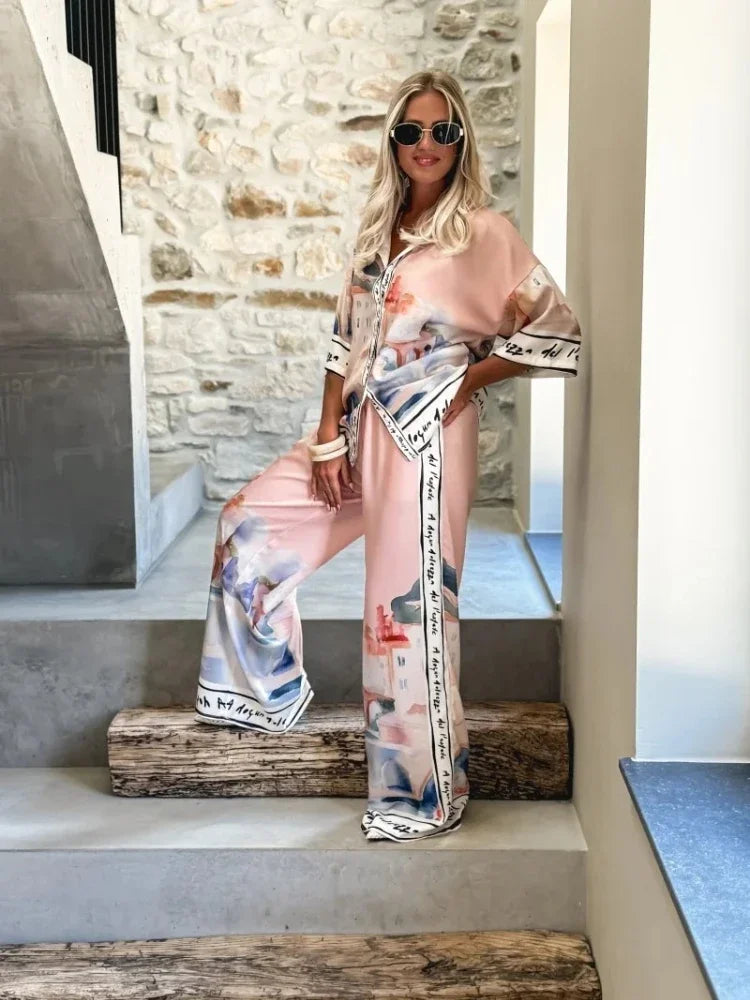Woman in a floral outfit standing on stone steps with a stone wall background