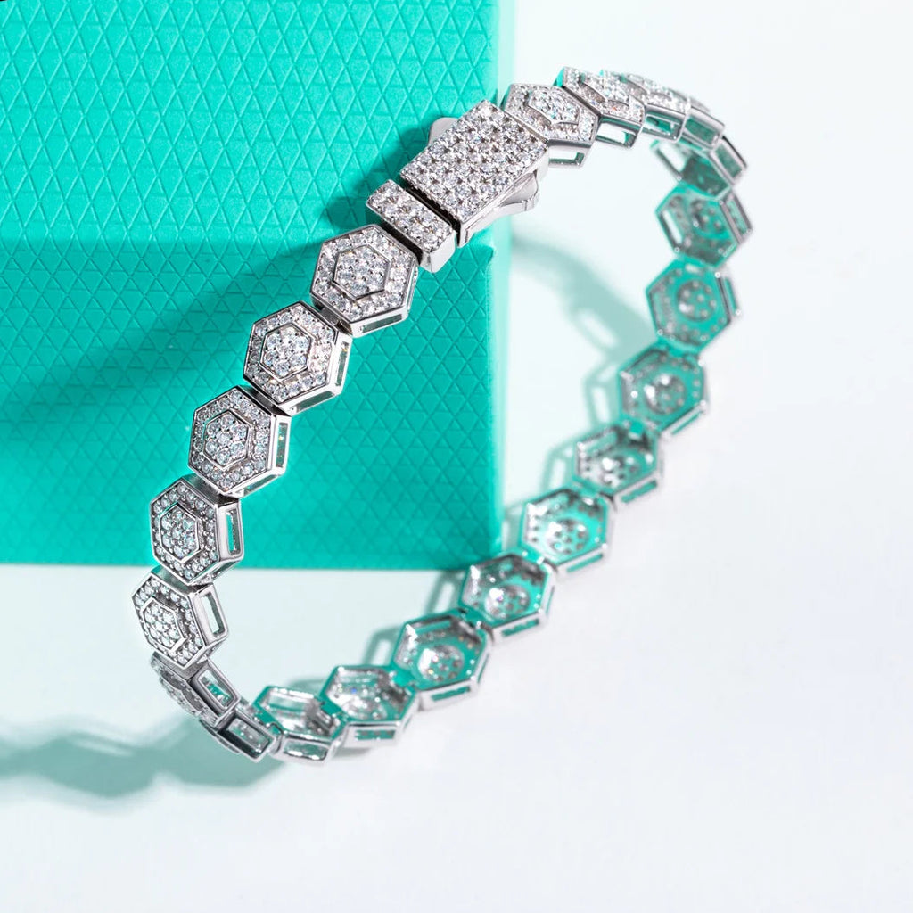 Silver bracelet with gemstones on a teal and white background, featuring the brand 'Anu Jewel'.