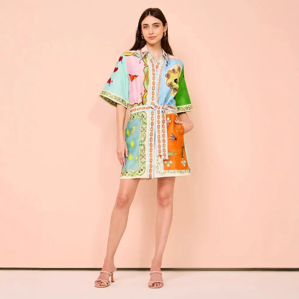 Woman wearing a colorful dress with a pattern on a pink background