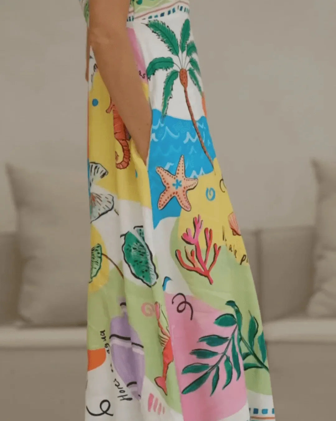 Colorful dress with marine-themed design worn by a person, blurred background