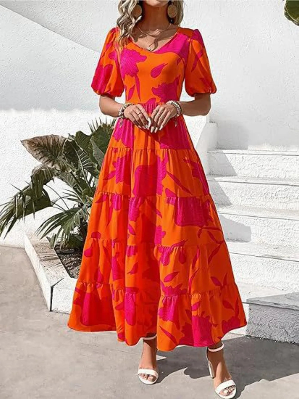 Woman wearing a colorful dress with a tiered skirt in an outdoor setting.