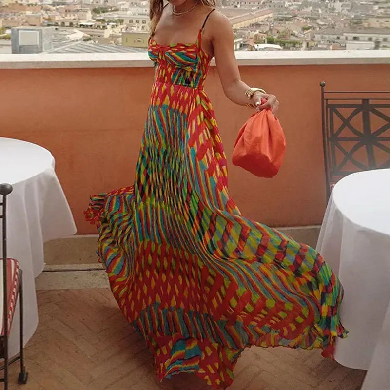 Woman in a colorful dress holding an orange bag on a rooftop with cityscape view