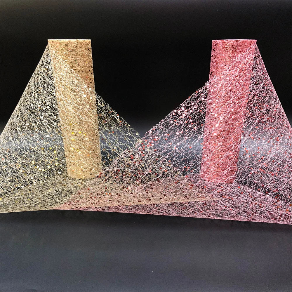 Two textured pillars, one gold and one pink, with a web-like material between them on a black background.