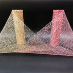 Two textured pillars, one gold and one pink, with a web-like material between them on a black background.