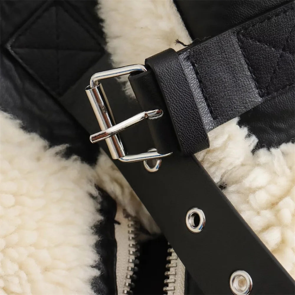 Close-up of a black strap with silver buckle on a textured surface