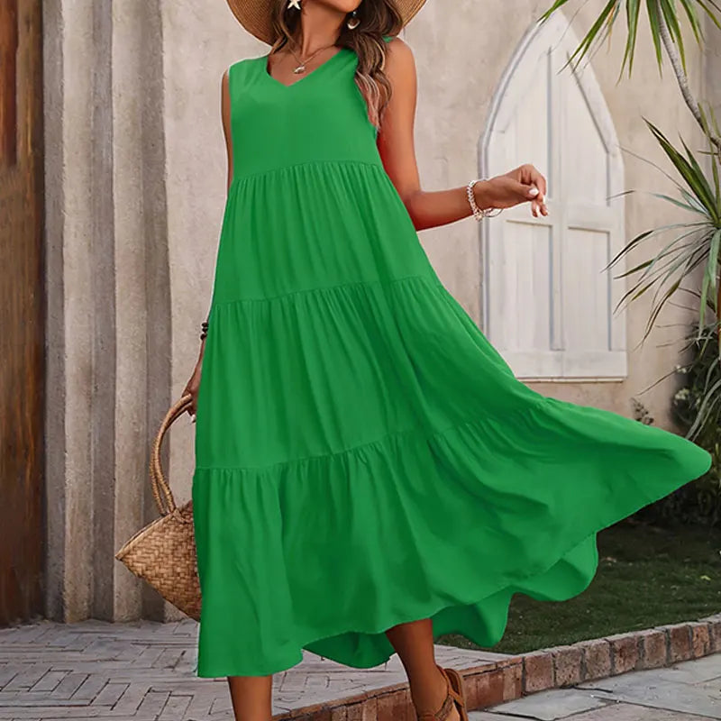 Woman wearing a green dress with a wooden wall and plants in the background