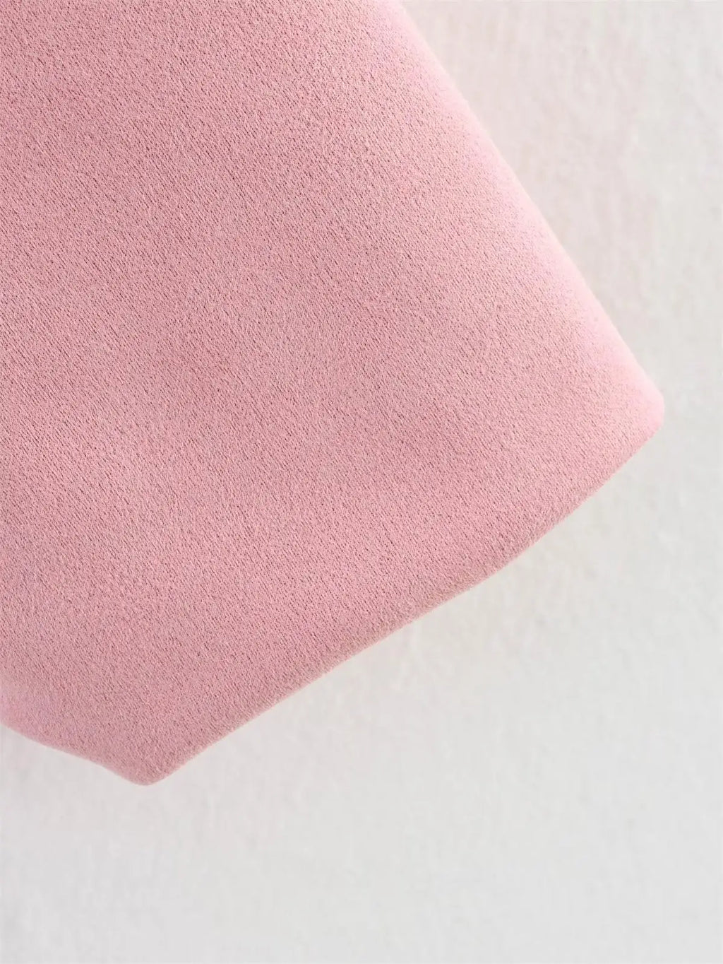 Close-up of a pink textured fabric on a light gray background