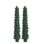 Two green tree-shaped candles on a white background
