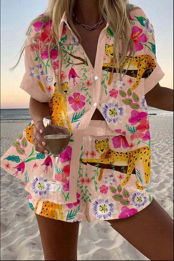 Person wearing a colorful floral and animal print outfit on a beach.
