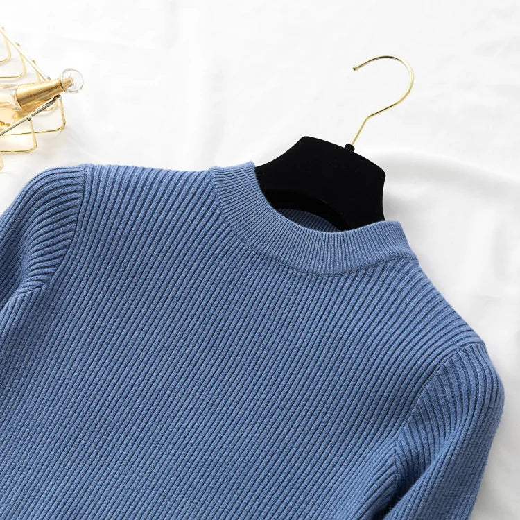 Blue sweater on a hanger against a white background