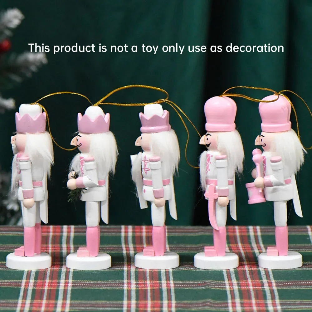 Set of decorative nutcrackers with pink and white attire on a plaid surface.