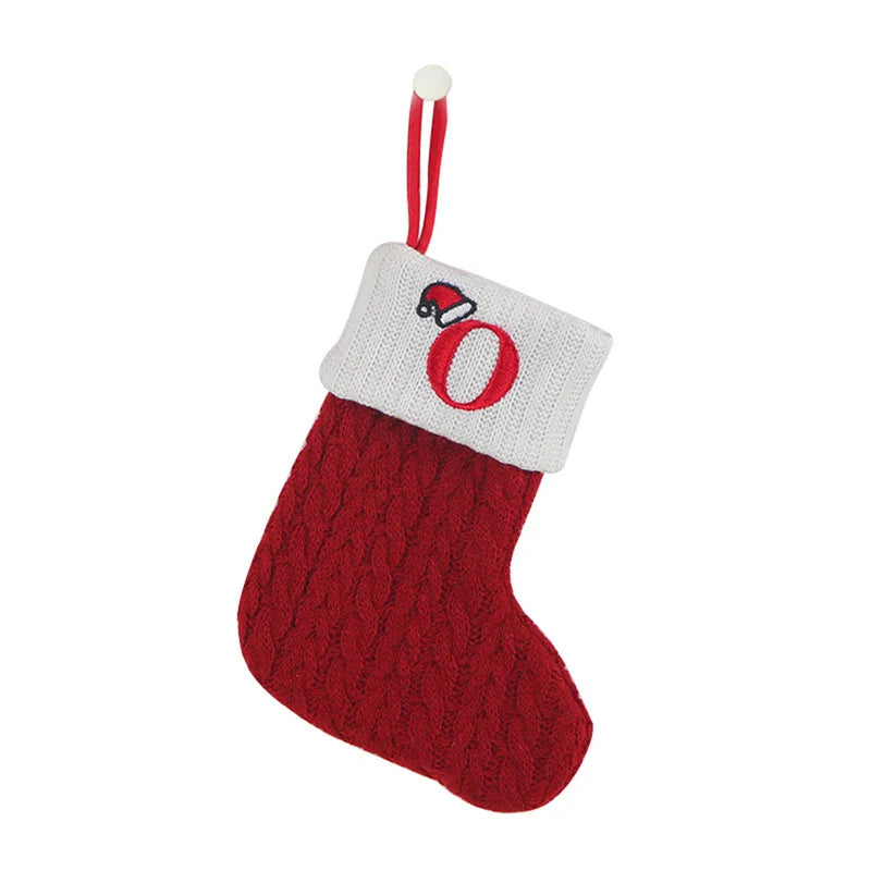 Red knitted Christmas stocking with a white cuff featuring a red letter 'O' and black Santa hat.