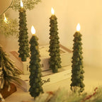 Green tree-shaped candles on a surface with a blurred background