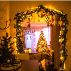 Decorated room with Christmas trees and garlands, warm lighting.
