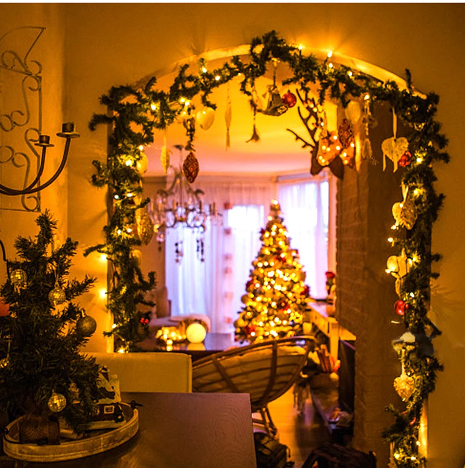 Decorated room with Christmas trees and garlands, warm lighting.
