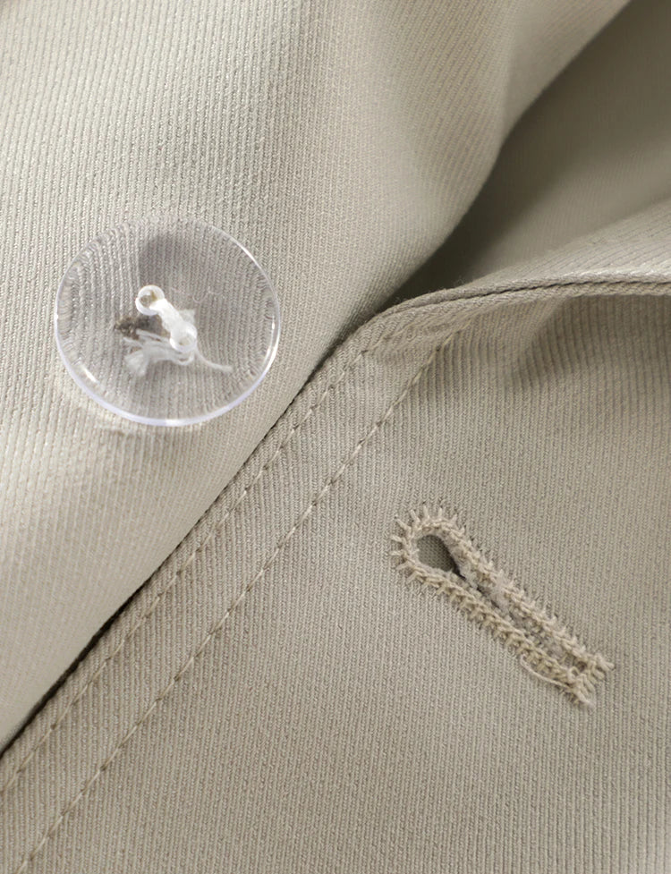 Close-up of a beige fabric with a button and stitching detail