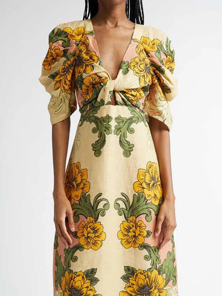 Woman wearing a floral dress with yellow and green flowers on a plain background