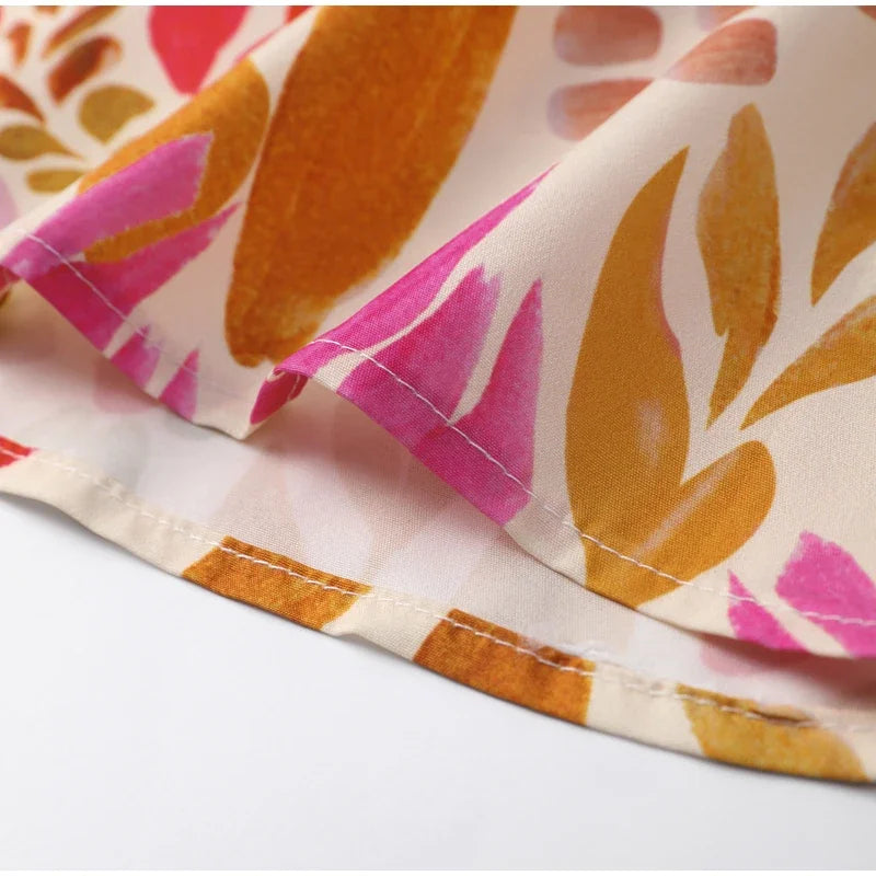 Close-up of fabric with pink and orange floral pattern on a white background